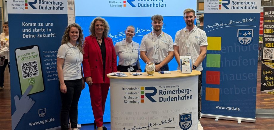5 Personen vor Messestand
